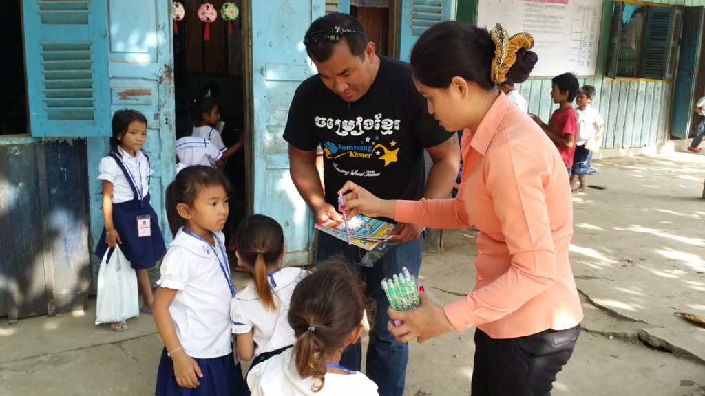 Kim handing out school supplies on his first trip to Cambodia
