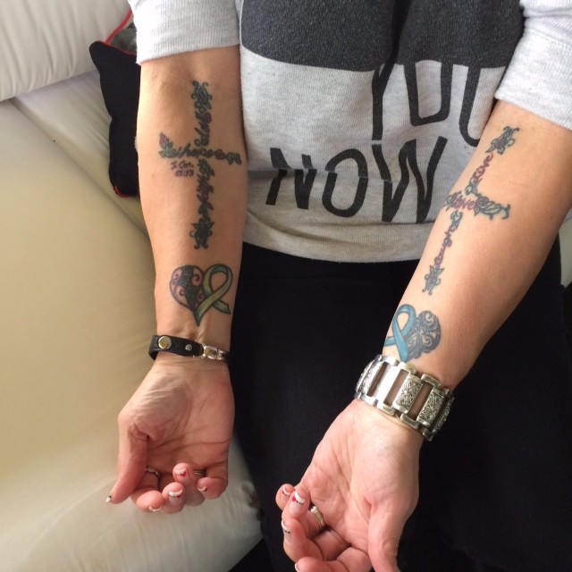 Remembrance cross and ribbon tattoos on Deborah's forearms