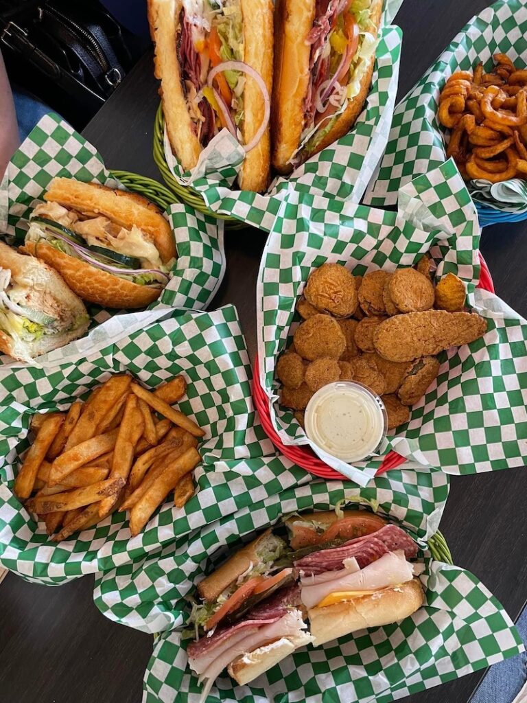 Assorted sandwiches, fries, and fried pickles from The Pickled Deli In Fresno CA